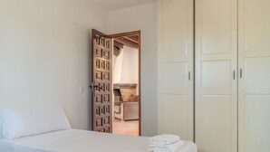Ein Schlafzimmer mit Bett, Schrank und einer Tür zu einem Badezimmer.