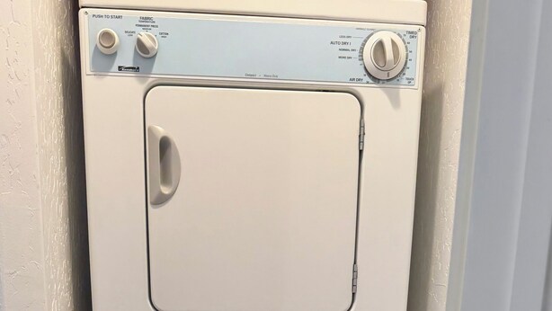 Un appareil compact combinant lave-linge et sèche-linge, doté d’un panneau de commande avec réglages de température et minuterie.