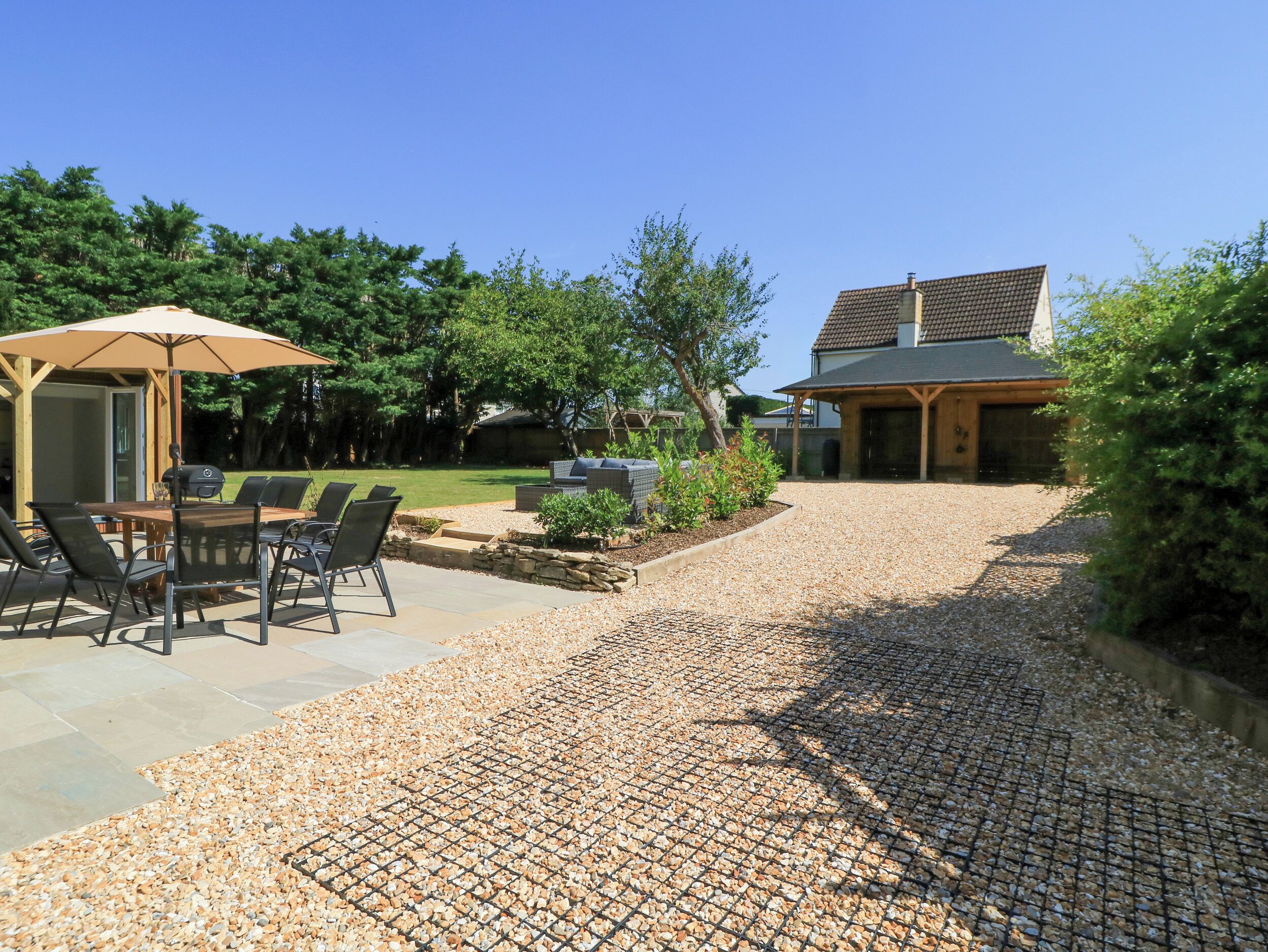 A patio area with outdoor furniture, a grill, and a covered seating area.