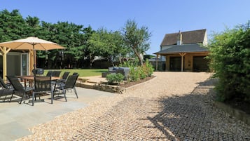 A patio area with outdoor furniture, a grill, and a covered seating area.