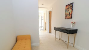 A hallway with a bench, a console table, and a painting on the wall. - Cern-wyn (Chippenham)