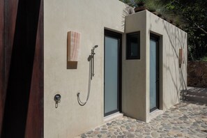 Ein modernes Gebäude mit einigem Pflasterstein-Belag im Eingangsbereich, einer beige farbenen Fassade und einer Glastür.