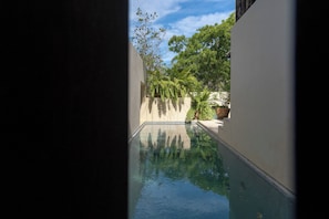 A swimming pool with a clear view of the sky and surrounding greenery.