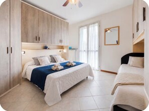 A bedroom with a bed, a wardrobe, a bedside table, and a mirror. - Casa delle Rondini - Pool, Relaxation, and Lake Garda (MANERBA DEL GARDA)