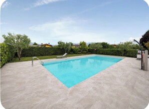 A rectangular swimming pool with a clear blue water surface, surrounded by a paved deck. - Casa delle Rondini - Pool, Relaxation, and Lake Garda (MANERBA DEL GARDA)