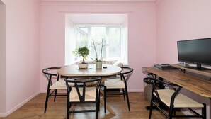 A dining area with a round table, four chairs, a television, and a window with blinds. - Bright, Leafy Oasis in South London - Pass the Keys (London)