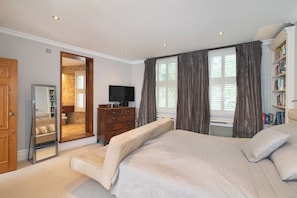 A bedroom with a bed, a dresser, a television, and a bookshelf. - Stylish Stockwell House with Garden & Comfort  - Pass the Keys (London)