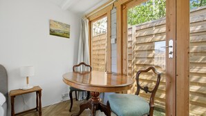 Ein Essbereich mit Holztisch und Stühlen, einer Lampe und einem Gemälde an der Wand.