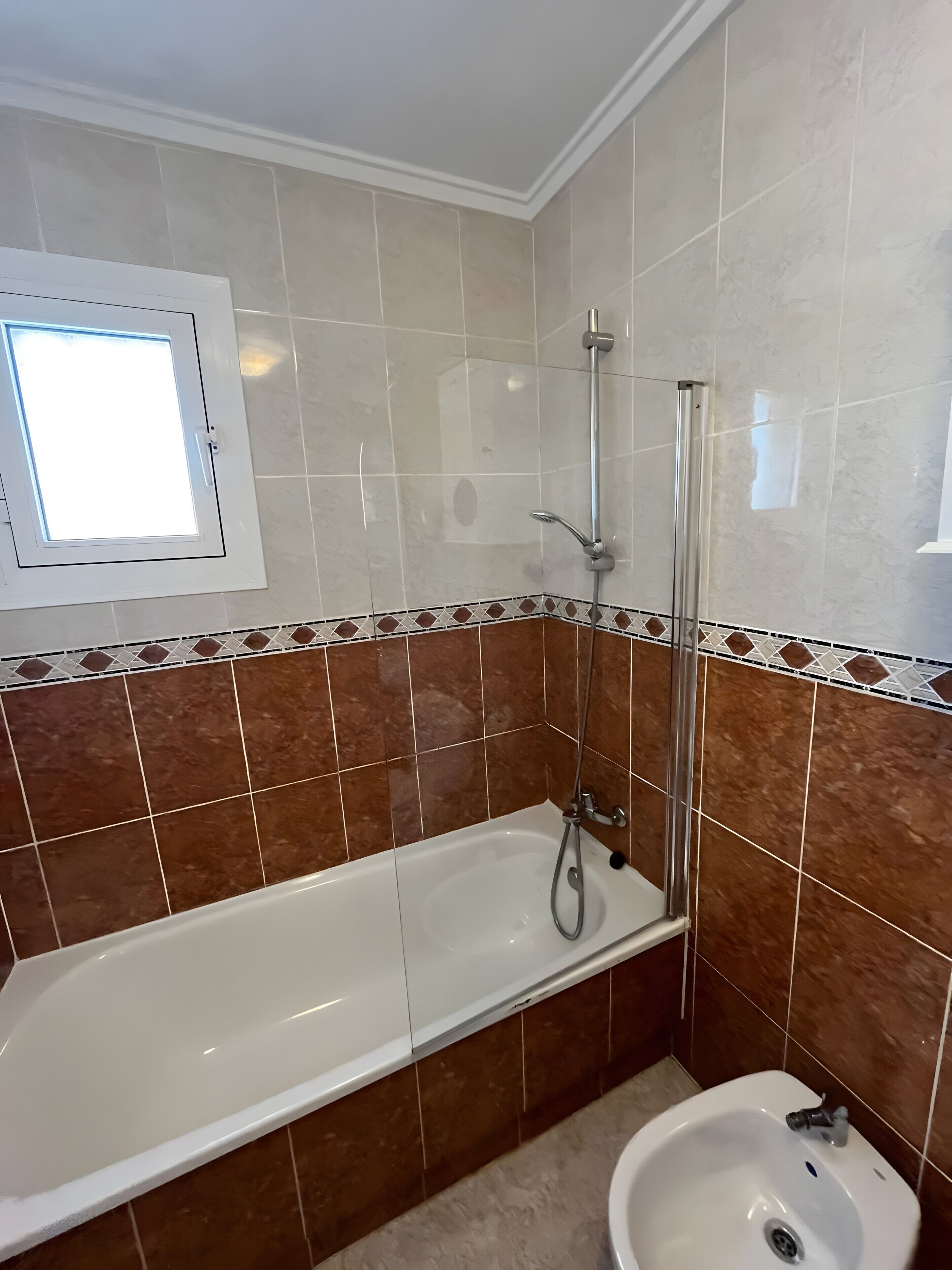 A bathroom with a bathtub, a shower, and a sink.