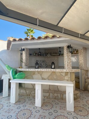 An outdoor bar area with a stone counter, two black lanterns, and a clock. - Villa 'Casa Familia Thijssen' with Private Pool, Wi-Fi and Air Conditioning (Mazarrón)