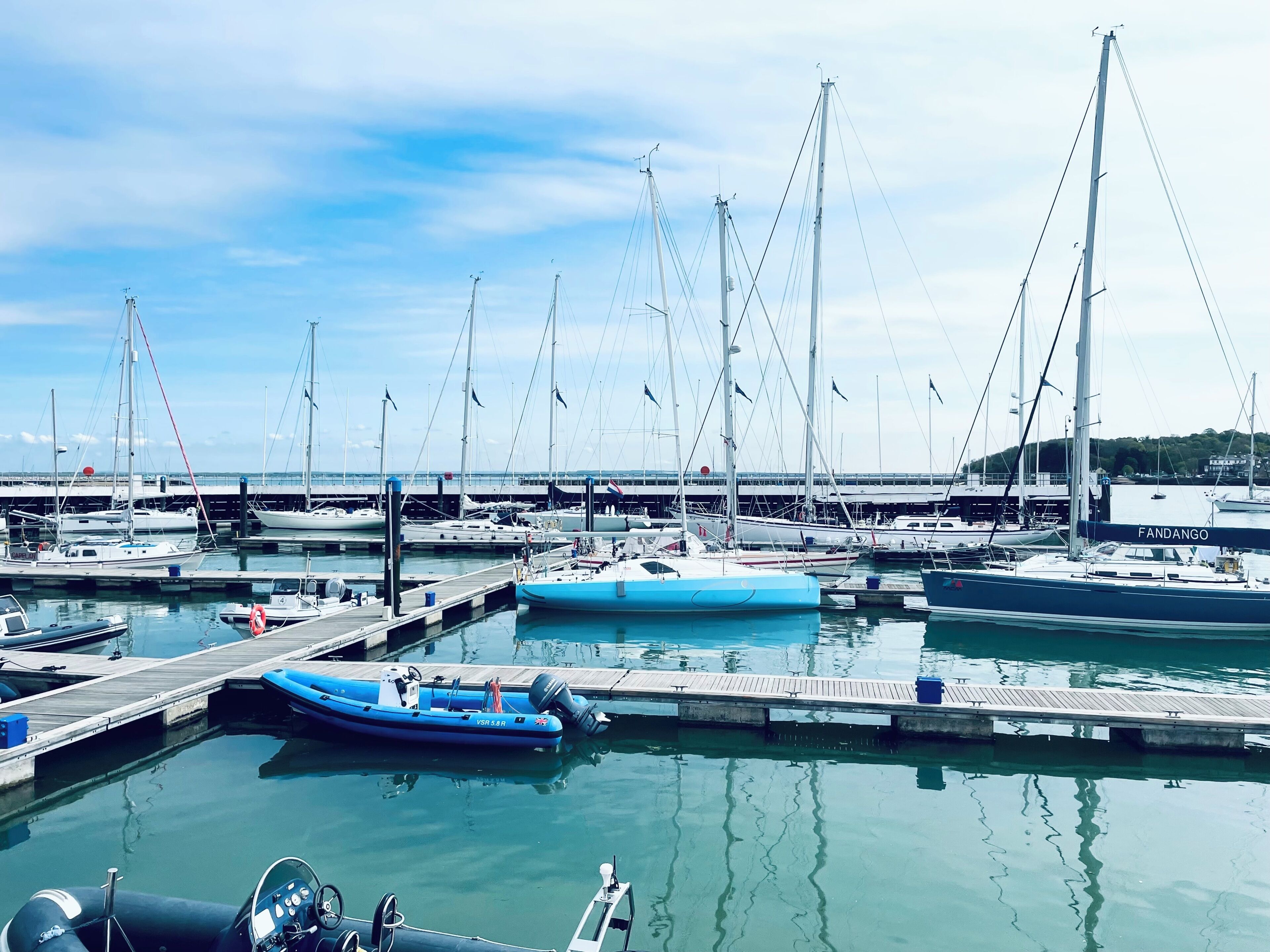 Un port de plaisance où de nombreux bateaux sont amarrés à des quais en bois.