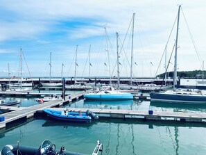 A marina with multiple boats docked at wooden piers.