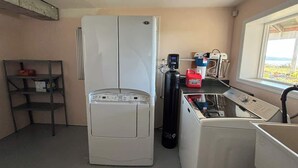 A compact kitchen with a refrigerator, a coffee maker, and a sink. - Sunset Shores Retreat (Powell River)
