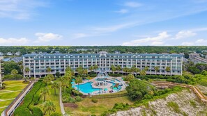 A hotel with a large pool area, multiple balconies, and a view of the surrounding greenery. - Bridgewater 427 Beautiful Renovated condo in Litchfield by the Sea! (Pawleys Island)