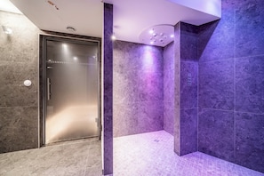 A modern bathroom with a glass shower enclosure, marble walls, and a tiled floor. - Altis - Terrace | Spa | Ski locker | Alpe d'Huez (Huez)