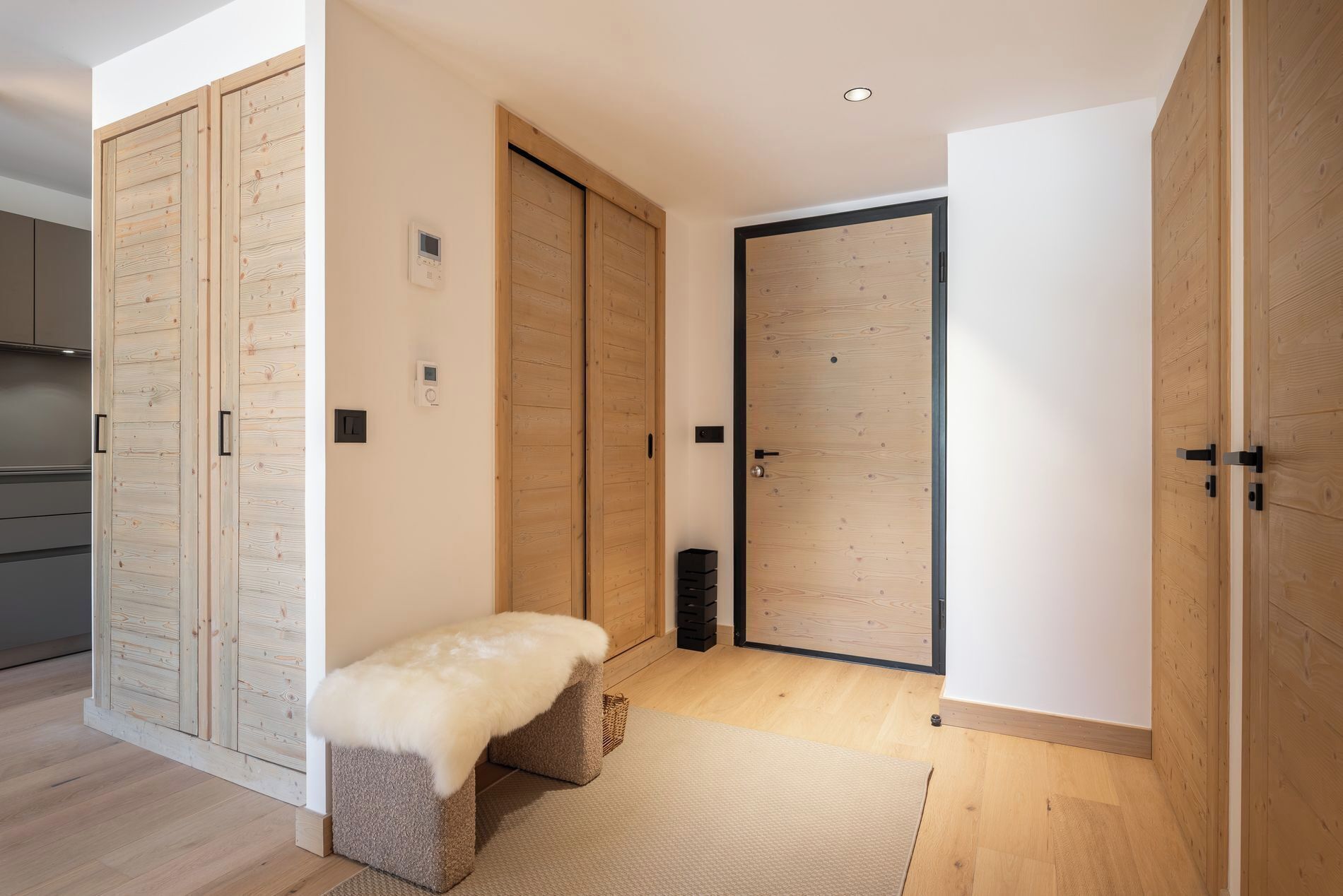 A modern interior with wooden paneling, a bench, and a sliding door.