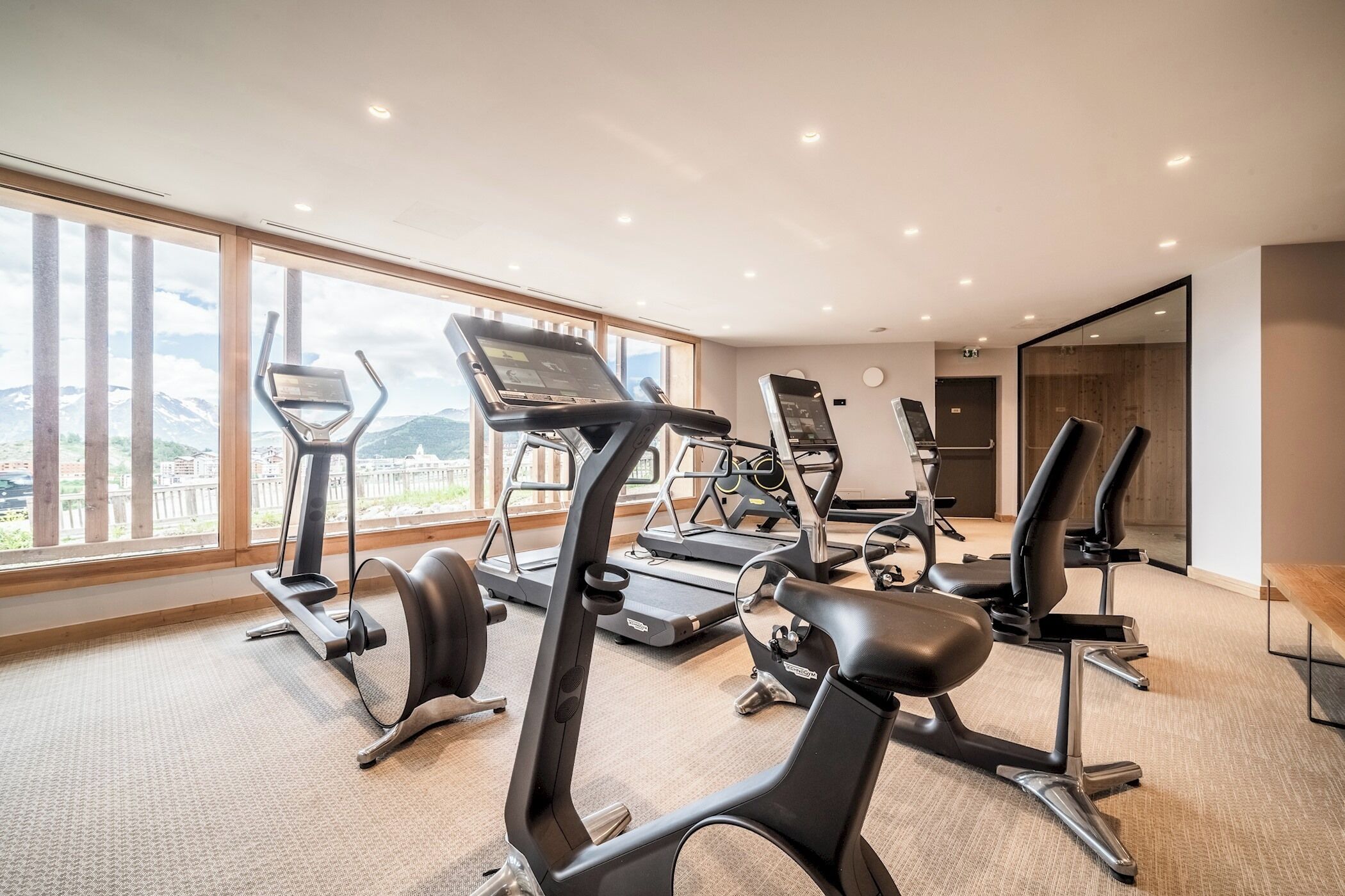 Ein Fitnessstudio mit Laufbändern, Ergometer und Crosstrainern.