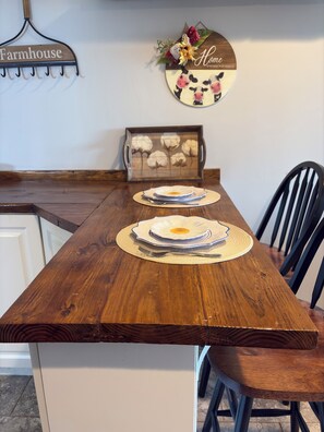 A wooden dining table with placemats and a decorative plate.