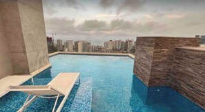 A rooftop swimming pool with a view of high-rise buildings. - Ocean View 2BR Pool & Gym Barranco-Miraflores (Lima)