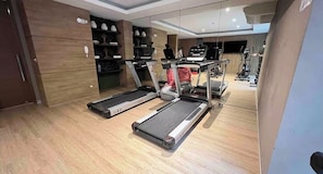 A modern gym with treadmills, exercise equipment, and a wooden floor. - Ocean View 2BR Pool & Gym Barranco-Miraflores (Lima)
