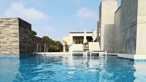 A swimming pool with clear blue water, surrounded by modern buildings and a clear sky. - 2-bedroom apartment w/ sunset view - Pool - Gym, beautiful Barranco y Miraflores (Lima)