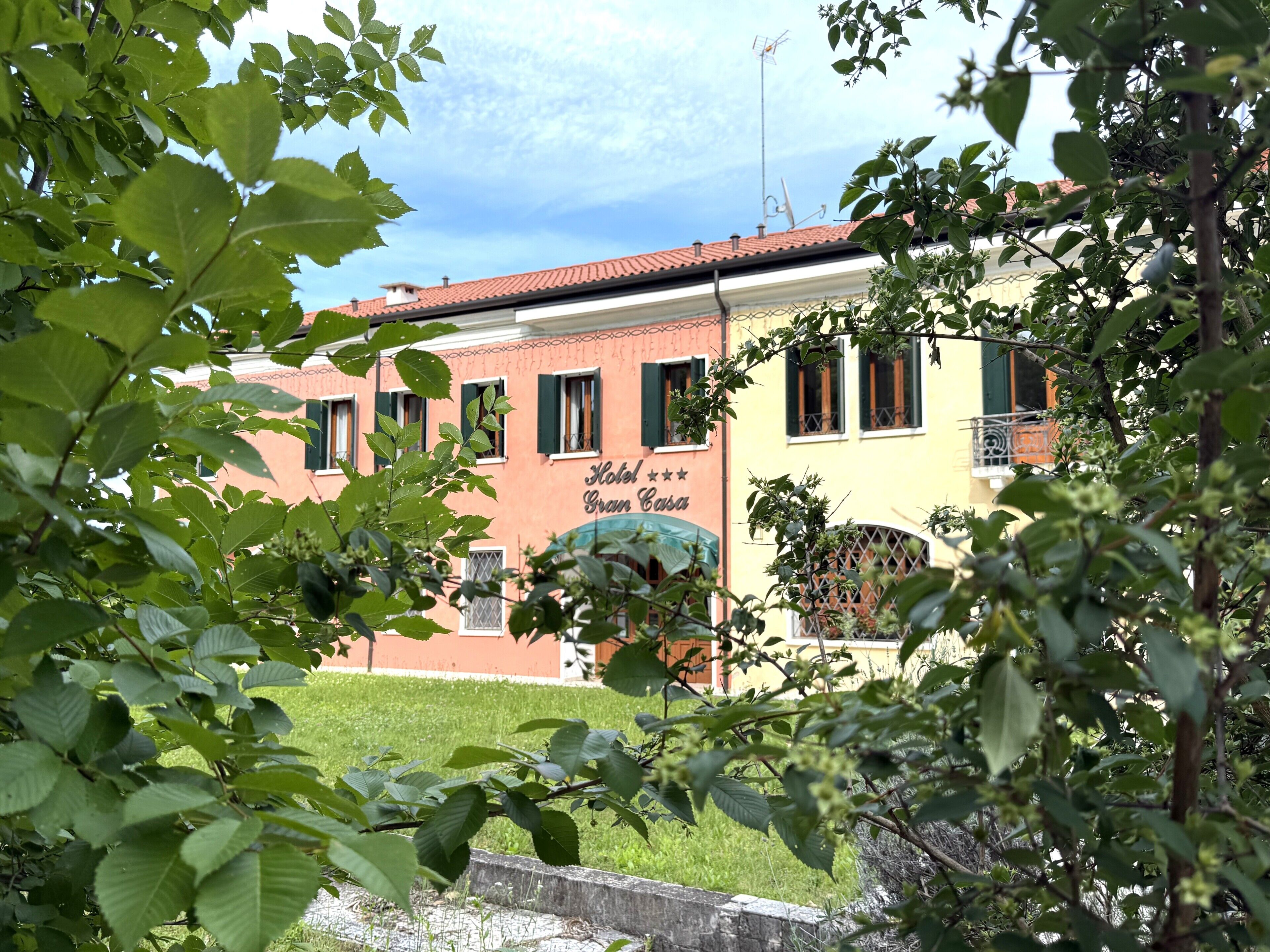 A hotel with a red facade, multiple windows, and a sign that reads 'Hotel Gran Casa.'