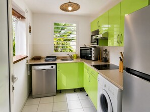 A compact kitchen with a dishwasher, microwave, toaster, and washing machine. - Villa Carbea (Saint François)