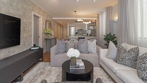 A modern living room with a flat-screen TV, a coffee table with decorative items, a sofa with patterned cushions, and a kitchen in the background. - Dolce Vita | Luxury 3 bed Retreat (Cape Town)