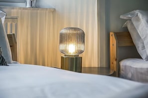 A bed with a bedside lamp, a wooden nightstand, and a headboard. - Modern - 2BR Flat near Easter Road Stadium (Edinburgh)