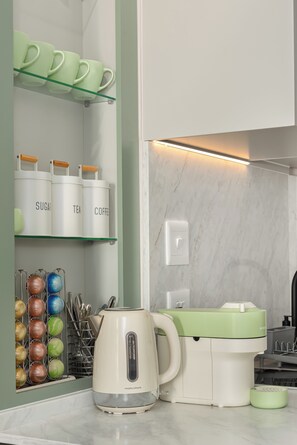 A kitchen with a kettle, a coffee maker, and storage containers labeled 'SUGAR,' 'TEA,' and 'COFFEE.' - Charlie and the Chairman Modern CBD Retreat (Cape Town)