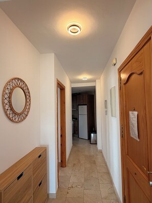 Ein Flur mit einem Holzschrank, einem runden Spiegel und einer Tür mit einem Zettel.