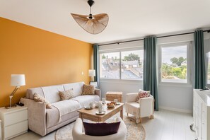 Ein stilvolles Wohnzimmer mit einer Couch, einem Couchtisch, einem Beistelltisch und einem Sessel.