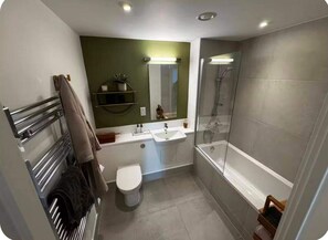 Ein modernes Badezimmer mit einer Duschkabine, einer Toilette und einem Waschbecken.