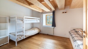 A room with a bunk bed, a window with curtains, a radiator, and a door. - Le Refuge de La Forge - Charmante ferme rénovée (La Forge)