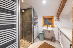 A bathroom with a shower, sink, and storage cabinets. - Le Refuge de La Forge - Charmante ferme rénovée (La Forge)