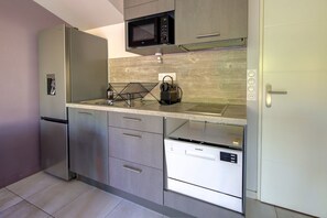A modern kitchen with a built-in microwave, a kettle, and a dishwasher. - Instant Evasion - Piscine Partagée (La Teste-de-Buch)