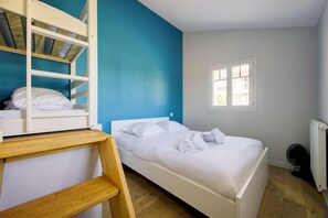 A bedroom with a bunk bed, a single bed, a window, and a radiator. - Instant Evasion - Piscine Partagée (La Teste-de-Buch)