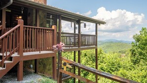 A wooden cabin with a balcony overlooking a forested landscape. - Full Arcade Game Room, Hot Tub & Mountain Views, Sleeps 10 Near Dollywood (Sevierville)