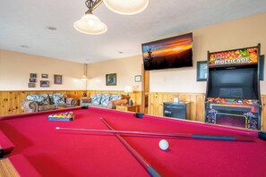 A pool table with a cue stick and balls, a sofa with cushions, a lamp, and a video game machine labeled 'MULTICADE'. - Full Arcade Game Room, Hot Tub & Mountain Views, Sleeps 10 Near Dollywood (Sevierville)