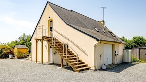 A two-story building with a wooden staircase leading to the upper floor. - Au pas de côté plourhannais - Proche Plage (Plourhan)