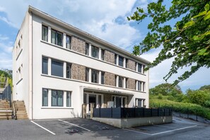 A modern multi-story building with a flat roof, large windows, and a parking area. - Le Beau Rivage - 1km de la Plage (Criel-sur-Mer)