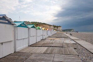 A wooden boardwalk leading to beach huts with a cliffside view. - Le Beau Rivage - 1km de la Plage (Criel-sur-Mer)