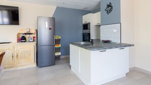 Una cocina moderna con una isla integrada, microondas, horno y refrigerador.