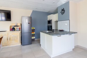 Eine moderne Küche mit integriertem Kochinsel, Mikrowelle, Backofen und Kühlschrank.