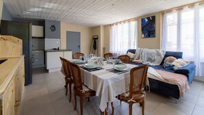 Comedor con una mesa dispuesta para cuatro personas, rodeada de sillas de madera.