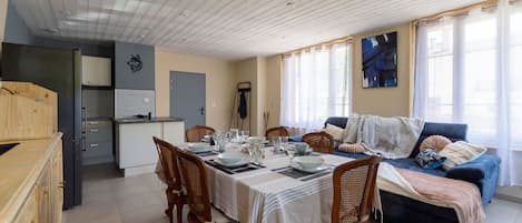 A dining area with a table set for four, surrounded by wooden chairs.