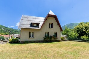 Una casa de dues plantes amb teulada inclinada i fonaments de pedra.