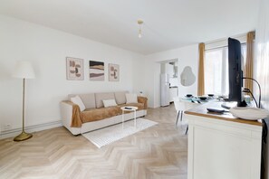 Ein modernes Wohnzimmer mit einer Couch, einem Couchtisch und einem Essbereich mit Tisch und Stühlen.