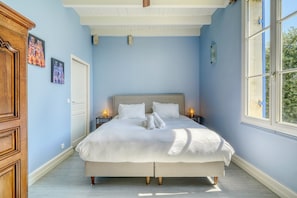 Ein Schlafzimmer mit einem großen Bett, einem Holzschrank und zwei Wandleuchten.