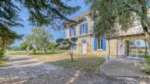 A stone building with blue shutters, a gravel path, and trees. - La Maison Sarreau Martin - Entre Vignes et Nature (Gardegan-et-Tourtirac)